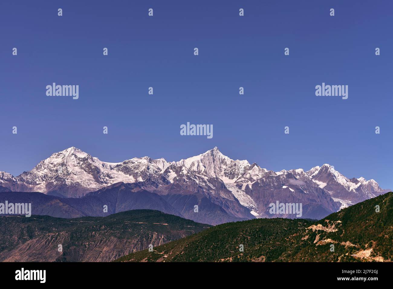 la catena montuosa dei meili innevati sotto il cielo blu nella provincia cinese del sichuan Foto Stock