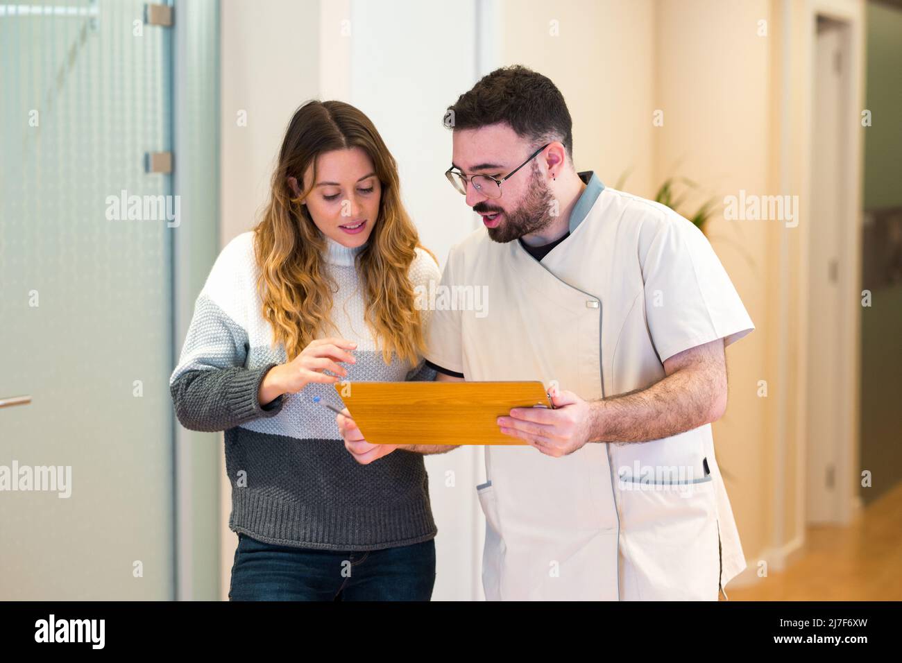 Infermiere che fornisce istruzioni e spiega qualcosa al paziente presso il centro medico. Foto Stock