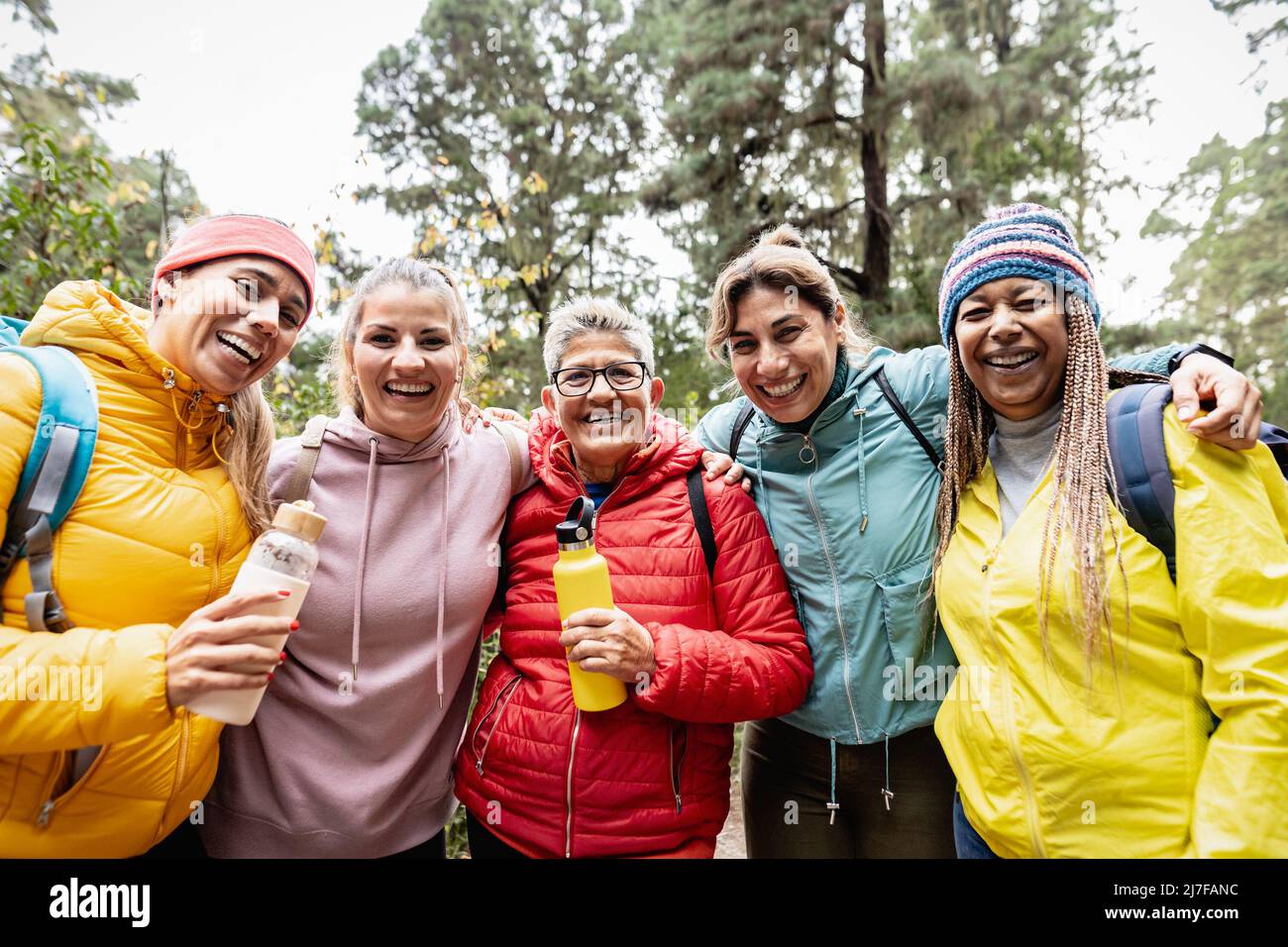Gruppo di donne con età ed etnie diverse che si divertono a camminare nei boschi - concetto di avventura e di persone di viaggio Foto Stock