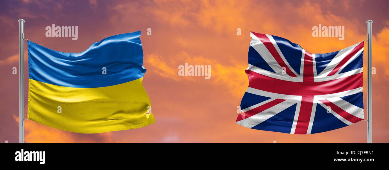 Ucraina e Regno Unito due bandiere su flagpoli e cielo blu. Aiuto militare in ucraina Foto Stock