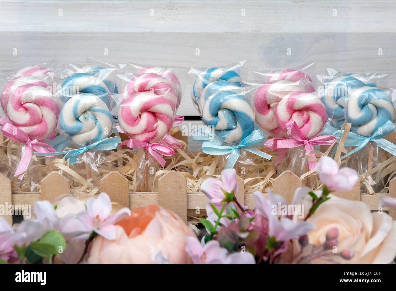Lollypops dolci colorati con archi. Zucchero caramella sui bastoni nella finestra del negozio, lollipops Foto Stock