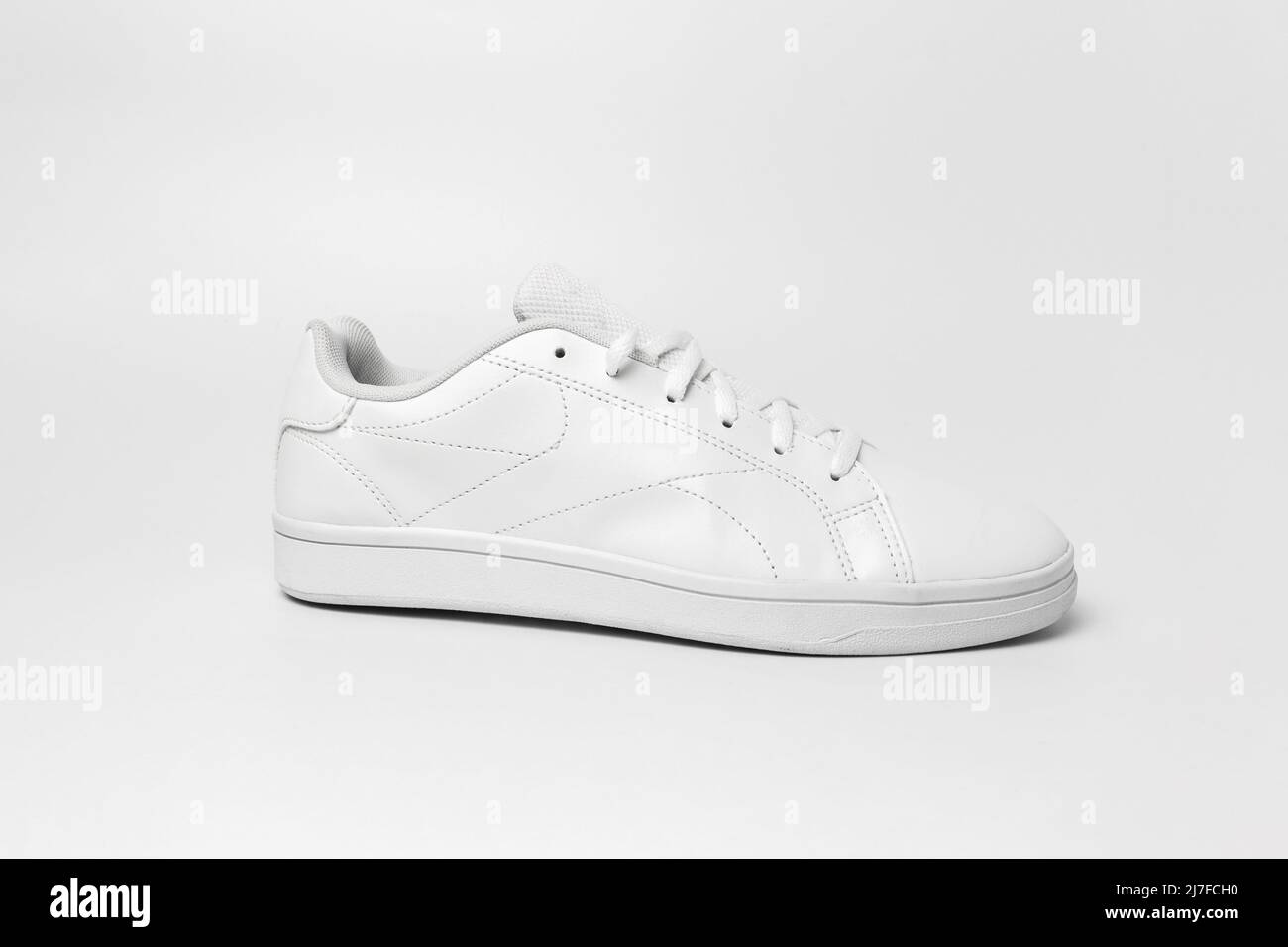 Vista laterale della sneaker bianca isolata su sfondo bianco per essere ritagliata. Scarpe sportive per mockup. Scarpe sportive casual alla moda. Foto Stock