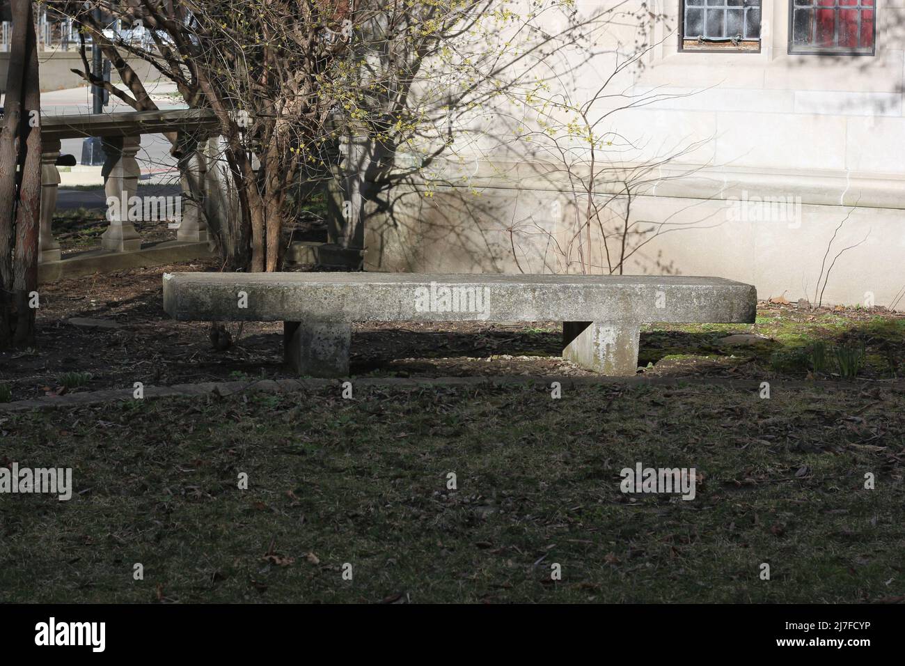 Panca in pietra vintage seduta vuota e accogliente nel cortile giardino gotico. Foto Stock