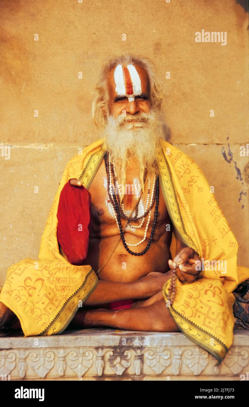 Ritratto di un sadhu indù seduto a gambe incrociate, Varanasi, Uttar Pradesh, India Foto Stock