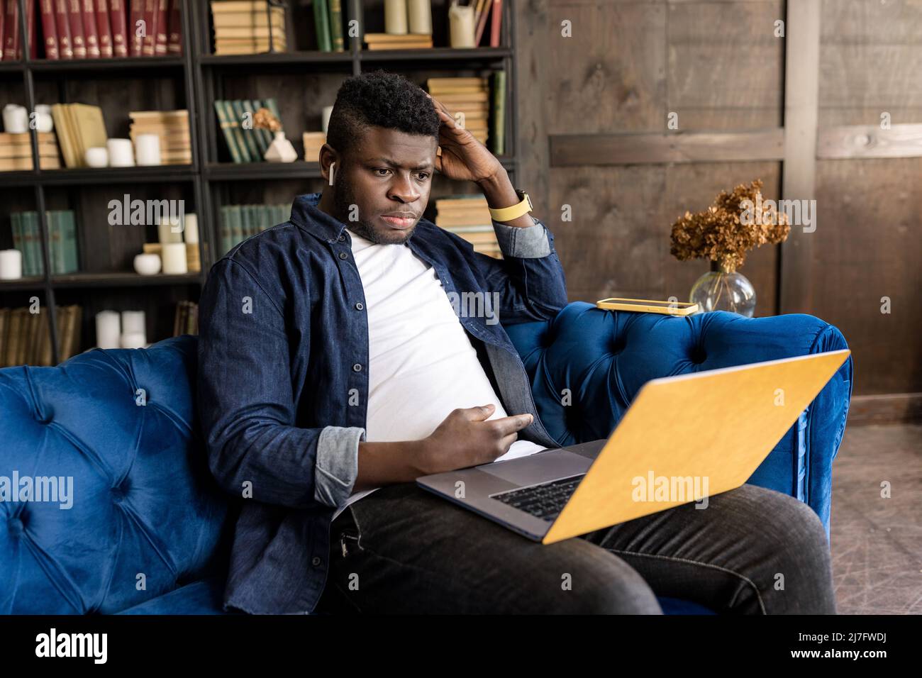 Giovane freelancer maschile afroamericano che lavora con i colleghi in videoriunione, utilizzando il laptop. Uomo d'affari elegante e cordiale che ha una videoriunione Foto Stock