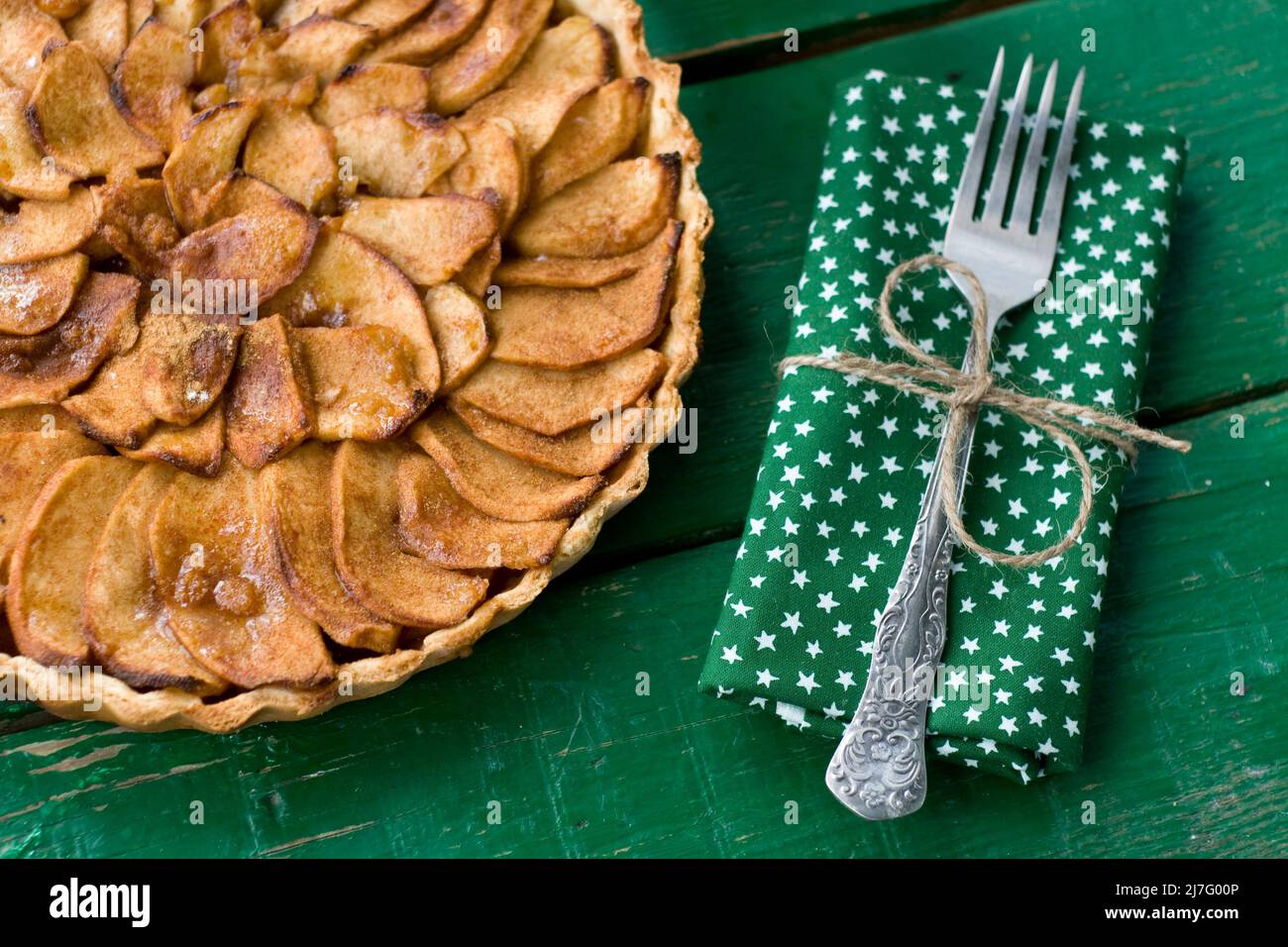 Torta di mele succosa con cannella e brandy su sfondo verde Foto Stock