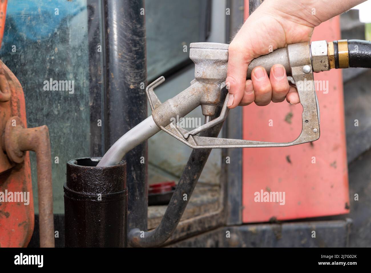 Farmer che riempie il trattore con diesel rosso in un'azienda agricola, North Yorkshire, Regno Unito. Foto Stock