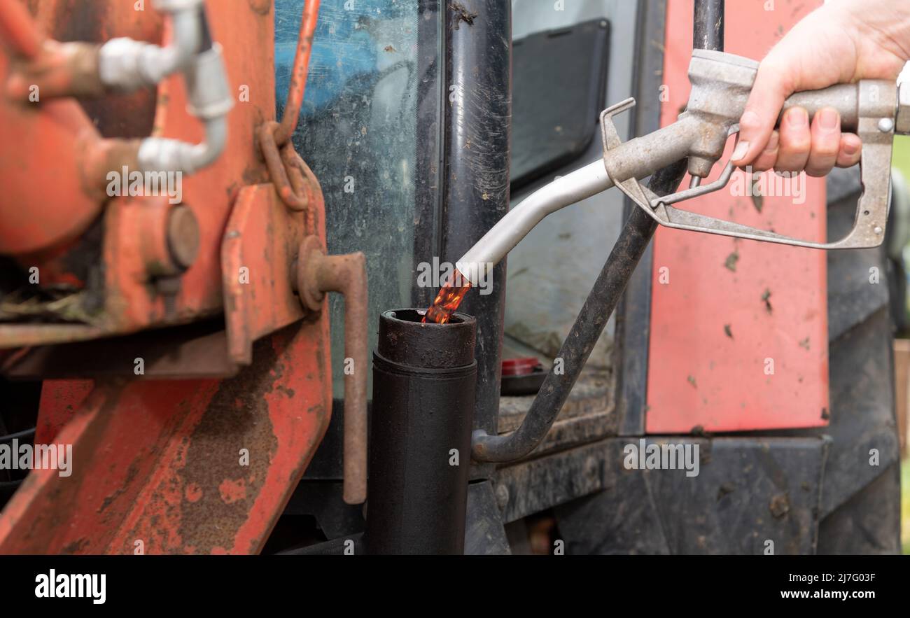 Farmer che riempie il trattore con diesel rosso in un'azienda agricola, North Yorkshire, Regno Unito. Foto Stock