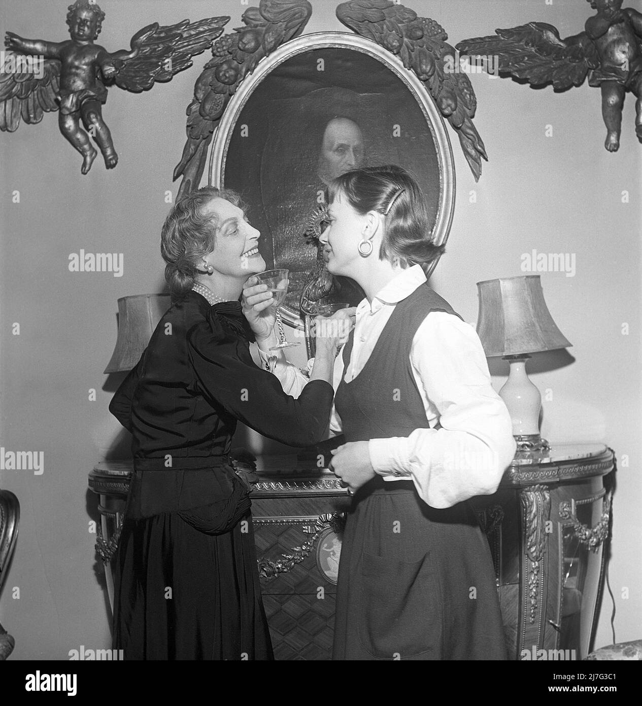Lancio dei titoli nel 1950s. L'attrice svedese Anita Björk a destra con la sig.ra Wingård visto eseguire un brindisi dove le loro braccia sono attraversate quando beve, il che significa che ora sono sulla base del nome, non più sconosciuti e l'etiquette di addessarsi l'un l'altro con i loro cognomi non è più neccesario. Foto scattata a Parigi 1951 quando il film Mademoiselle Julie sta avendo la sua prima apertura a le Vendome giugno 28 1951. Anita Björk è uno degli attori del film. Kristoffersson Ref BD23-5 Foto Stock