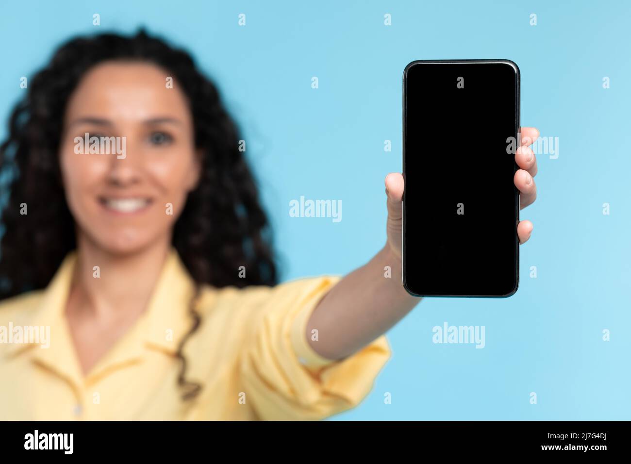 Primo piano di donna che tiene mostrando nero schermo vuoto smartphone Foto Stock