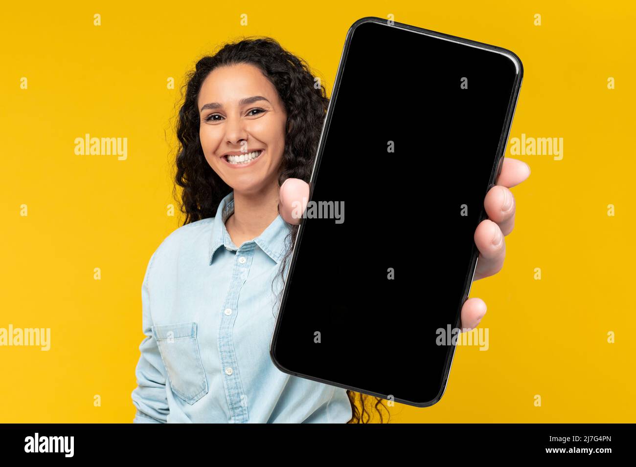 Signora eccitata che tiene in mano lo schermo vuoto dello smartphone Foto Stock