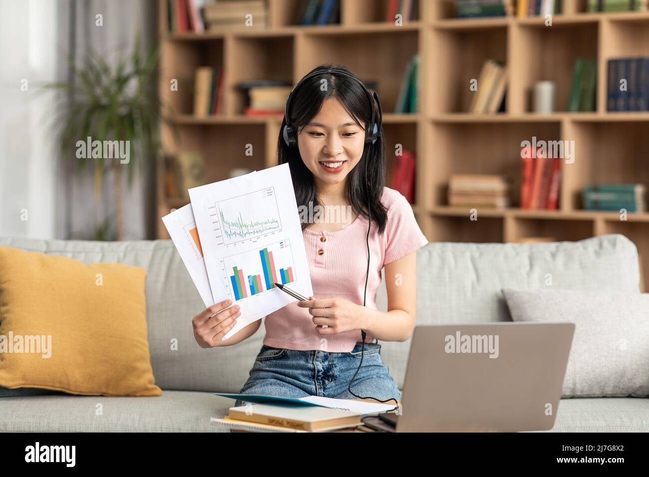 Riunione online. Il manager asiatico effettua una teleconferenza con i colleghi da casa, dimostrando il rapporto alla webcamera Foto Stock