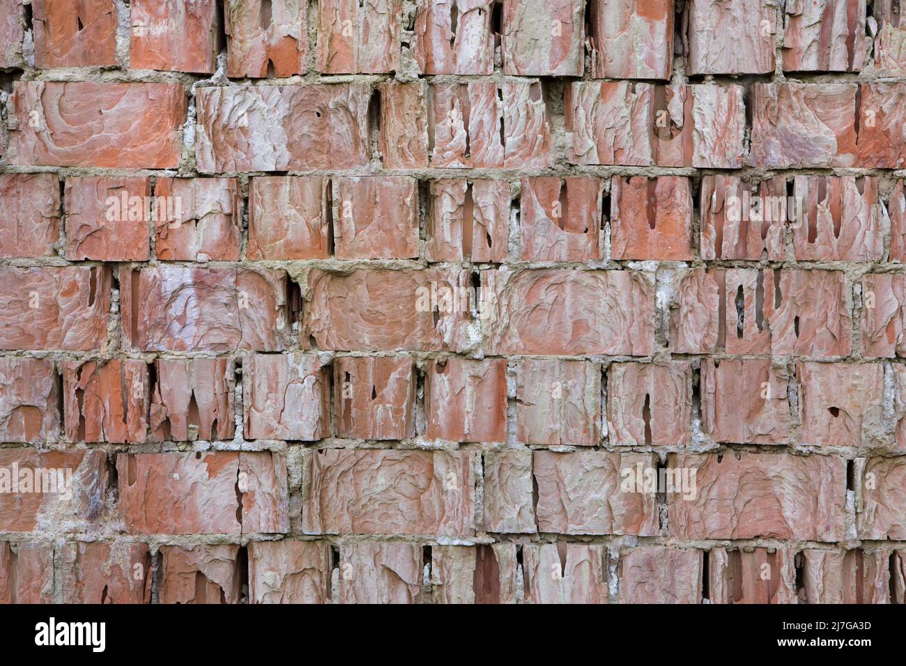 Muro di mattoni gravemente danneggiato. Texture di sfondo. Foto Stock