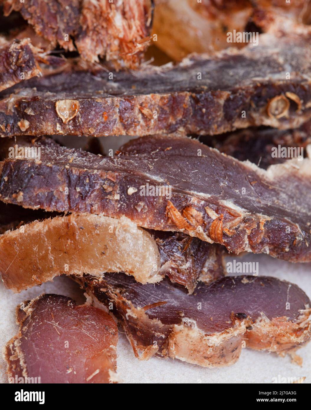 Biltong sudafricano, un affettato di carne secca e stagionata e su sfondo grigio con spazio copia Foto Stock