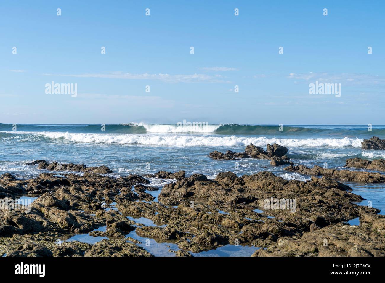 Onde perfette sulle rocce nella splendida spiaggia di Playa Hermosa. Surf a Santa Teresa, Costa Rica. Foto Stock