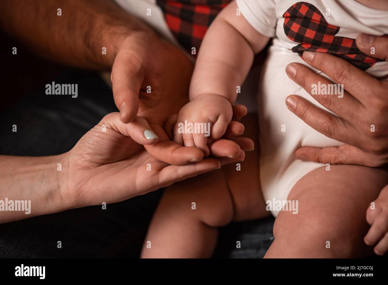 La mano del bambino è nelle mani dei genitori. Mamme e papà. Amore parentale. Famiglia Foto Stock