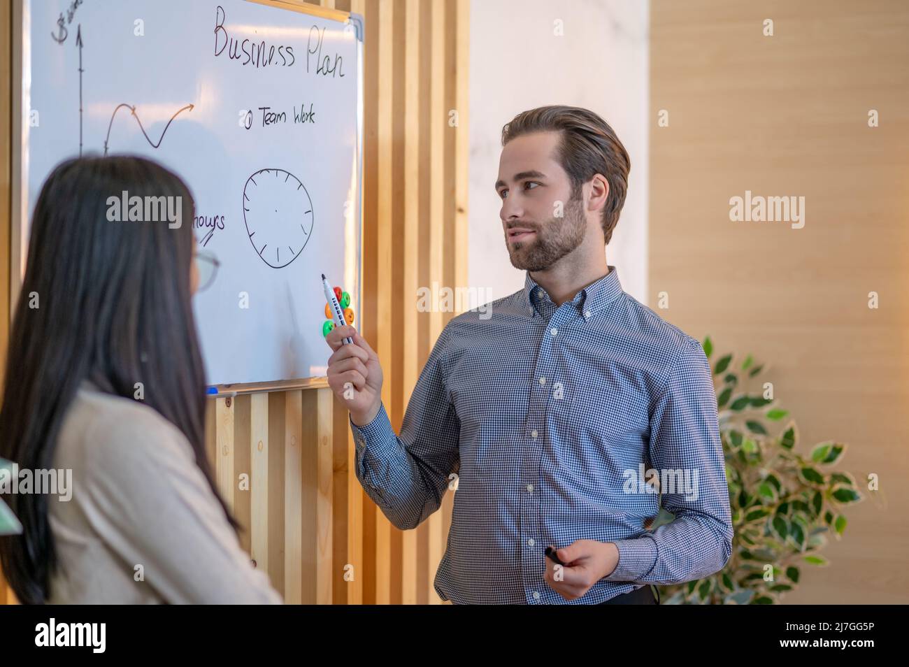 Dipendente aziendale che spiega il suo business plan a un collega Foto Stock