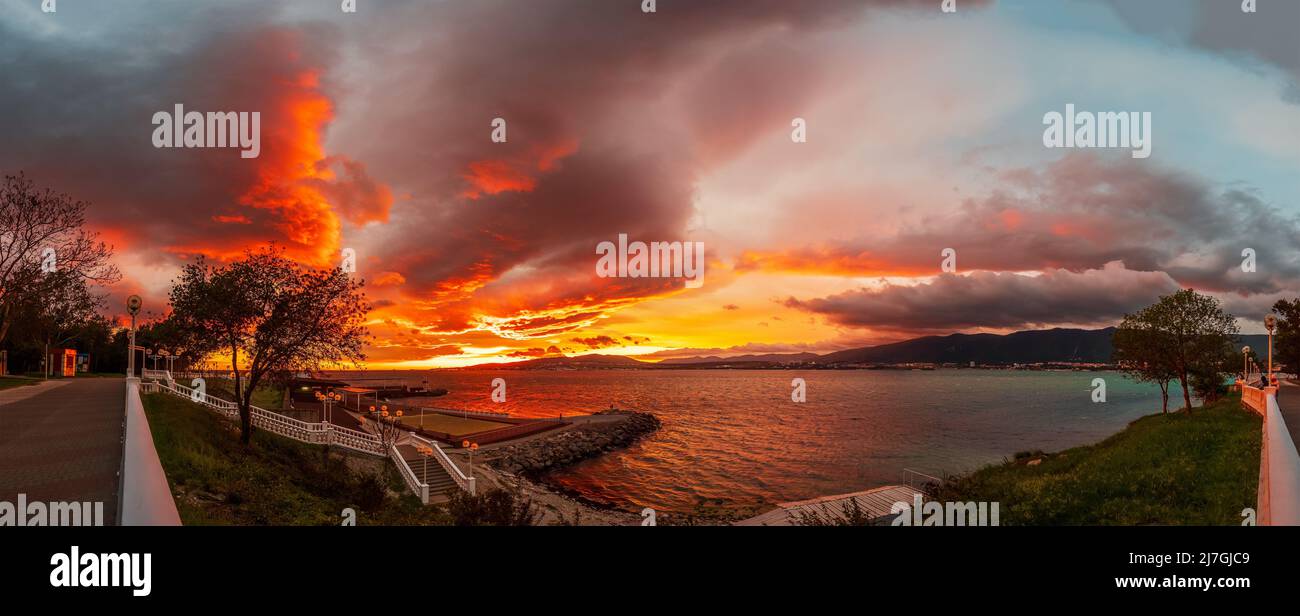 Incredibile e colorato tramonto con cielo nuvoloso luminoso sulla baia del mare in Gelendzhik panorama argine. Destinazioni di viaggio, resort estivo per viaggi e riposo. Foto Stock