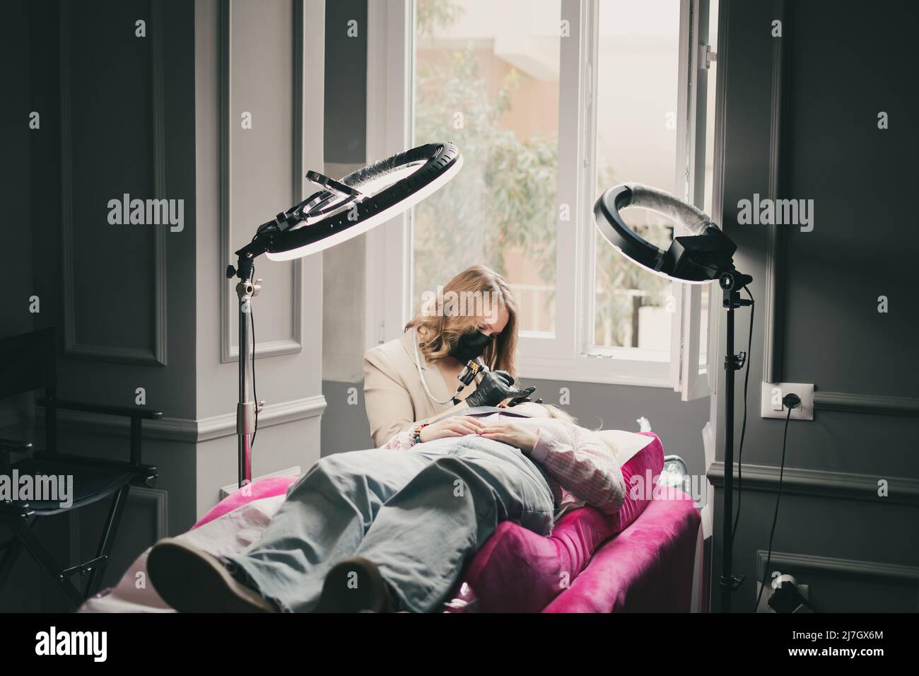 Cosmetologo che applica permanente compongono le sopracciglia per un cliente Foto Stock