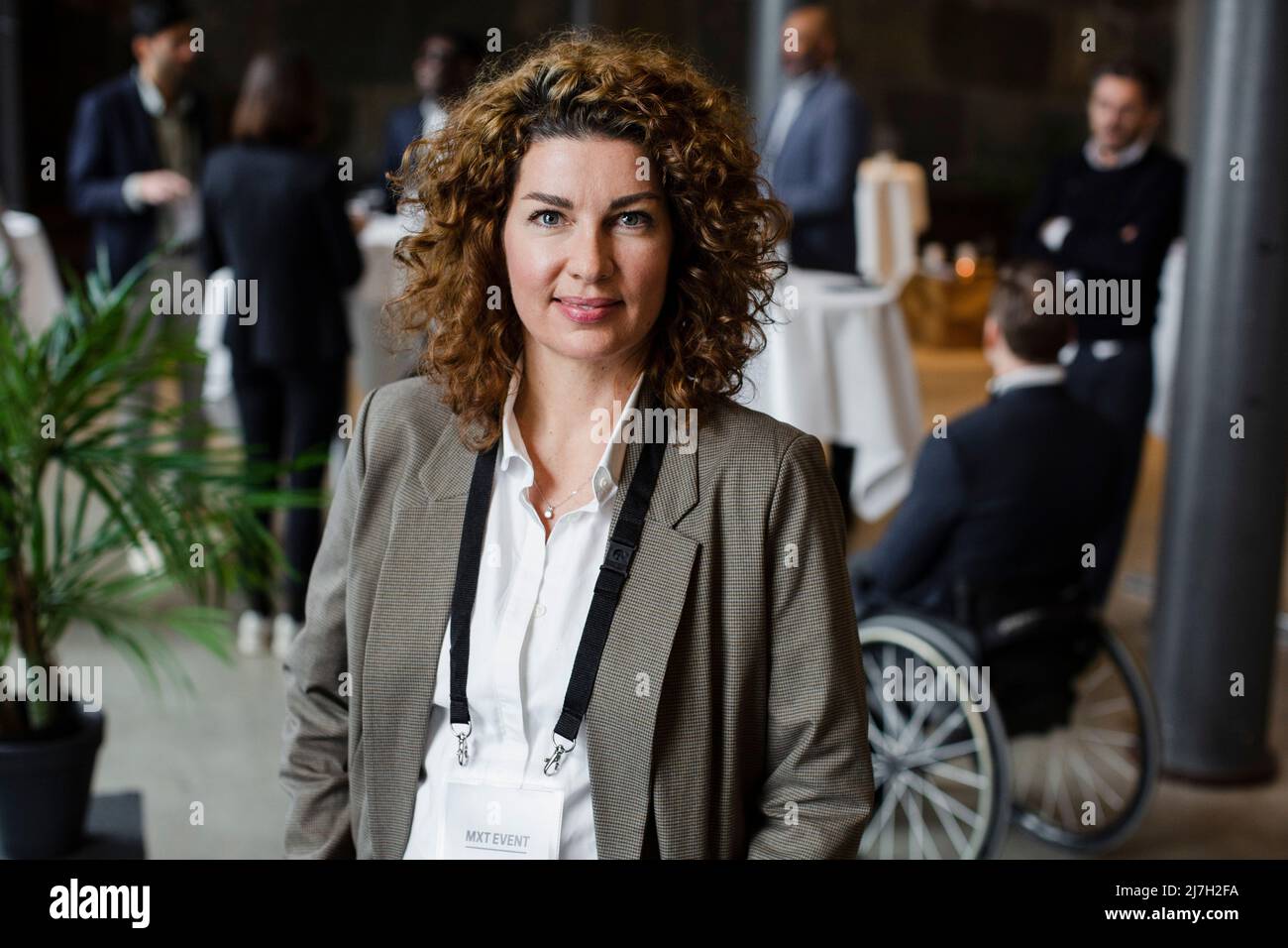 Ritratto di donna d'affari con capelli marroni curly al seminario Foto Stock
