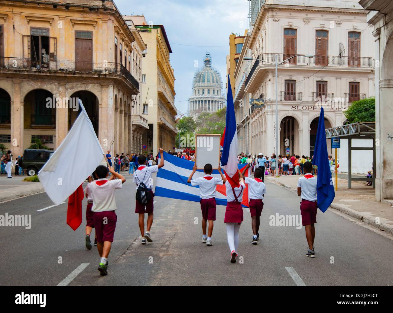 Studente cubano durante una sfilata per le strade di l'Avana, Cuba detiene una bandiera cubana e onorando l'eroe rivoluzionario cubano. Foto Stock
