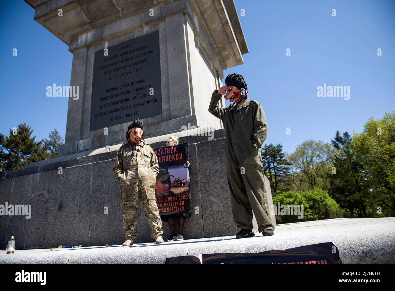 Un uomo vestito da soldato sovietico con una maschera di maiale sul viso saluta mentre si erge sul monumento ai soldati sovietici che sono morti nella seconda guerra mondiale Centinaia di ucraini e attivisti polacchi hanno protestato in un cimitero di Varsavia contro i soldati dell'Armata Rossa che sono morti durante la seconda guerra mondiale L'ambasciatore russo in Polonia, Sergey Andreev, è stato colpito con vernice rossa da manifestanti contrari alla guerra in Ucraina in un evento annuale della Giornata della Vittoria che commemorava la fine della seconda guerra mondiale L'ambasciatore Sergey Andreev è arrivato al cimitero dei soldati sovietici per deporre i fiori il giorno della Vittoria, ma il diplomatico e la sua delegazione sono stati costretti Foto Stock