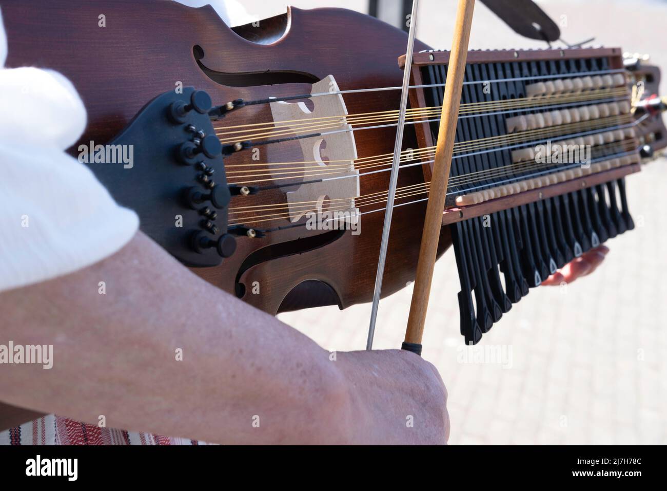 La donna suona musica folk su un nyckelharpa svedese in primo piano con particolare attenzione all'arco, agli archi e all'arco Foto Stock