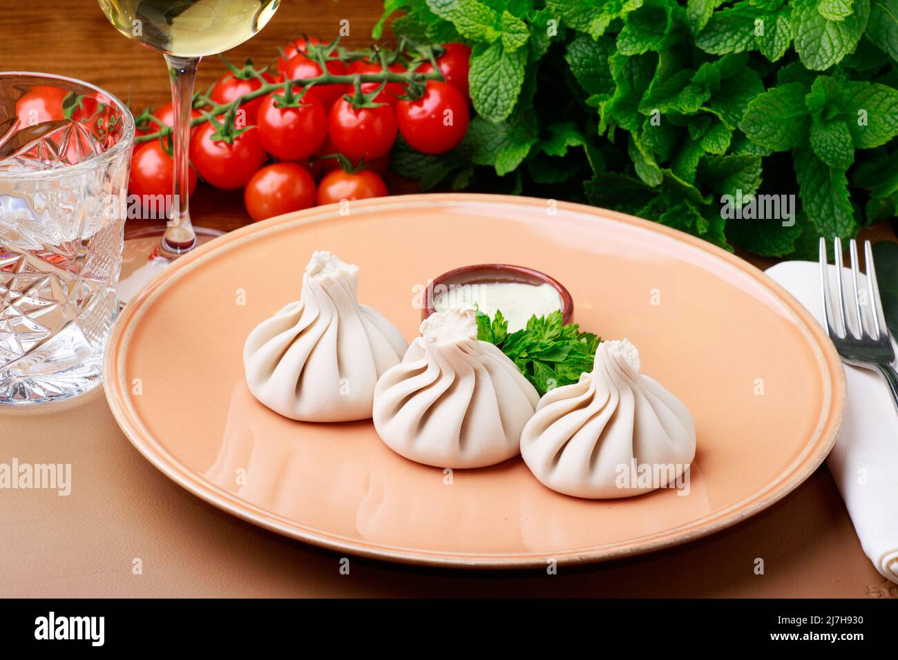 Khinkali - gnocchi tradizionali georgiani serviti con una salsa di panna acida e prezzemolo. Foto Stock