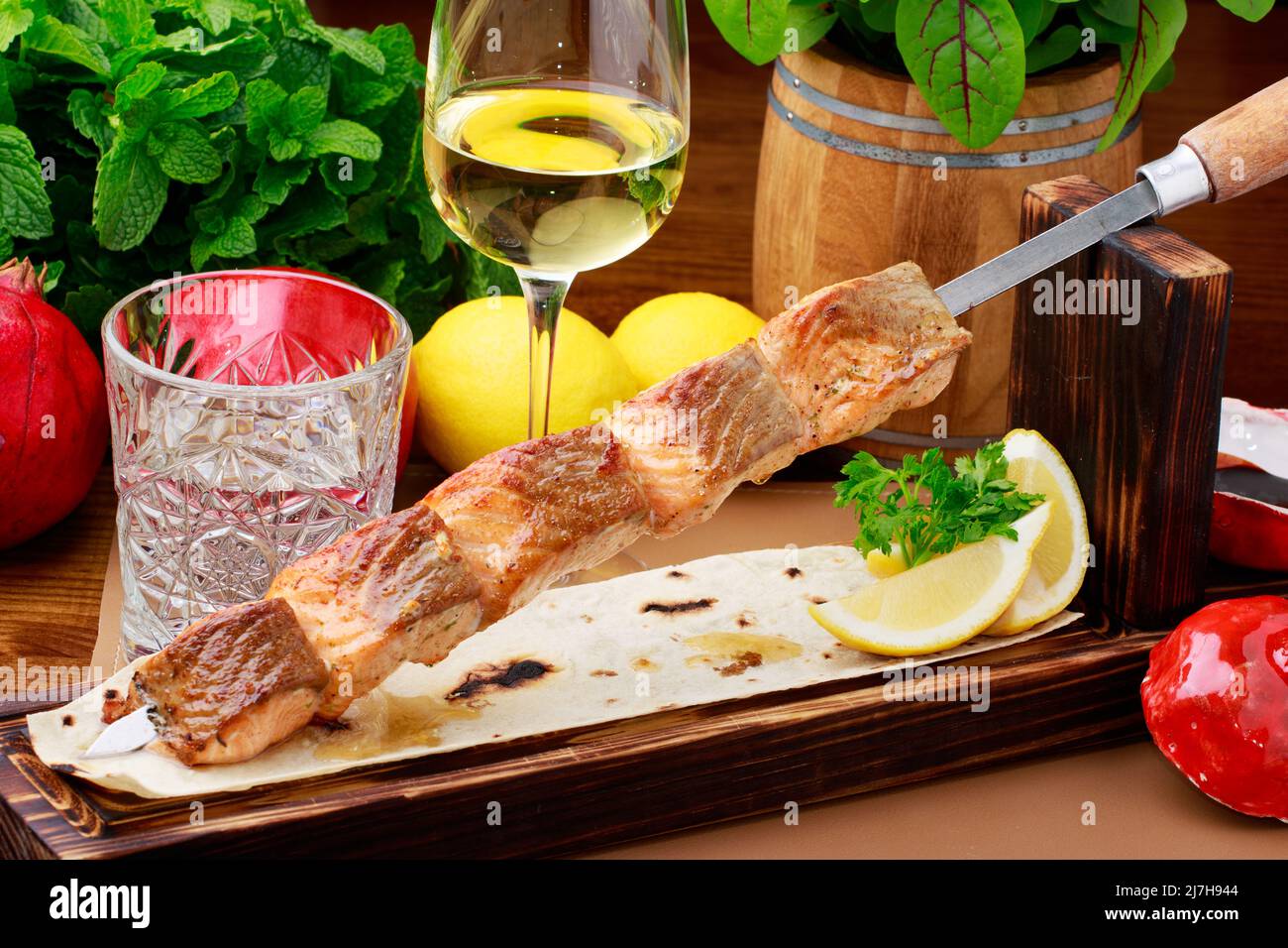 Salmone alla griglia su spiedini di acciaio inossidabile, servito su pane piatto con salsa di limone e Pomegrenate. Foto Stock