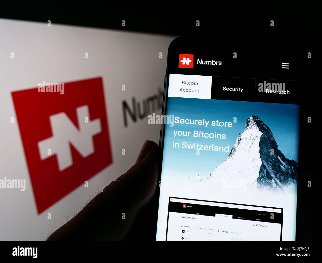 Persona che tiene il cellulare con il sito web della società FinTech Numbrs Personal Finance AG sullo schermo di fronte al logo. Concentrarsi sul centro del display del telefono. Foto Stock