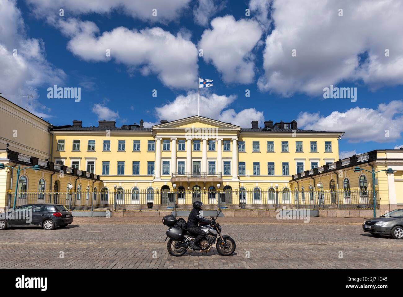 Una moto che guida di fronte al Finlands Presidents Palace Foto Stock