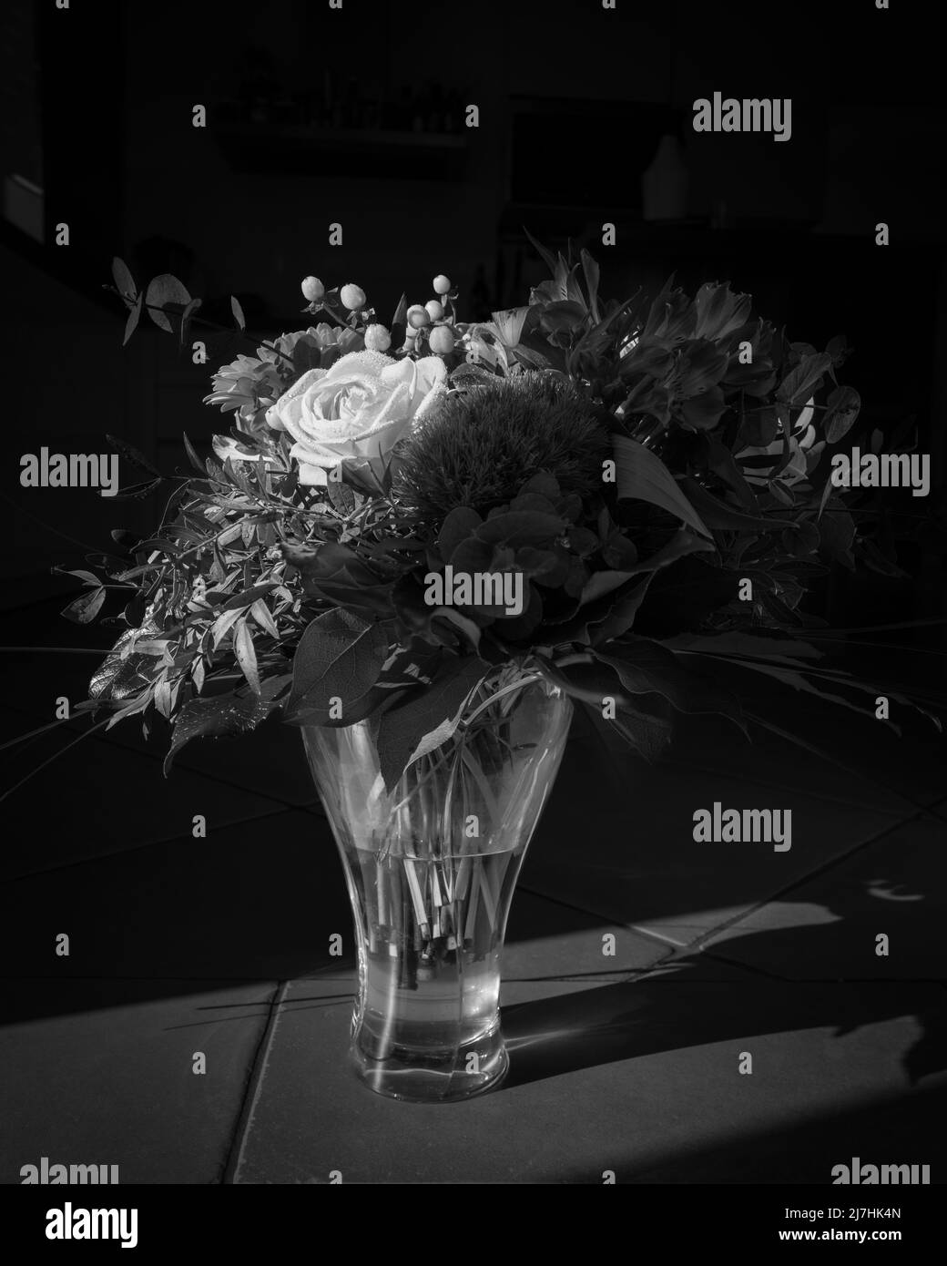 un grande bouquet di fiori si trova in un vaso in vetro bianco nero Foto Stock