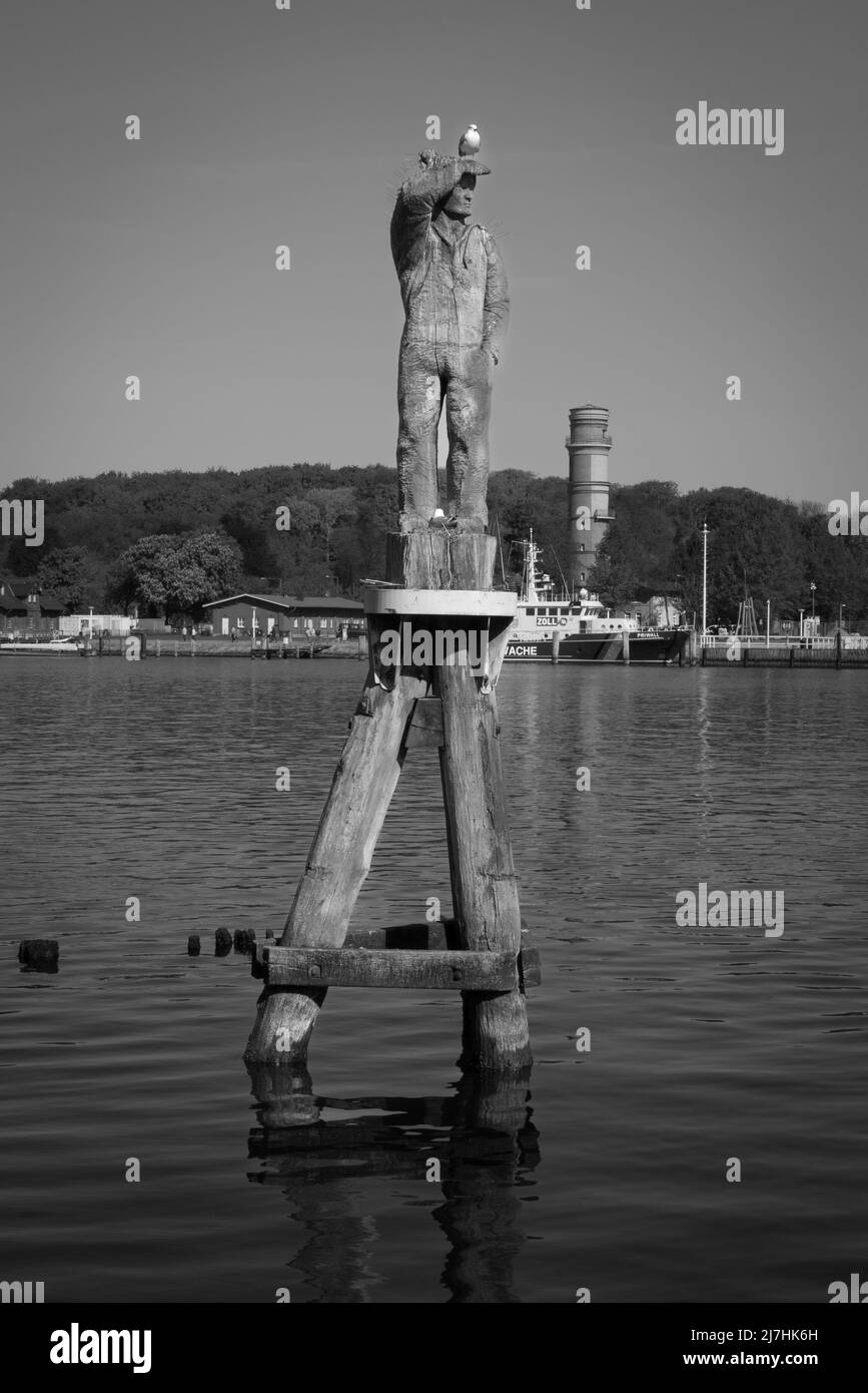 Un gabbiano su una statua di legno nel porto di Travemuende Foto Stock