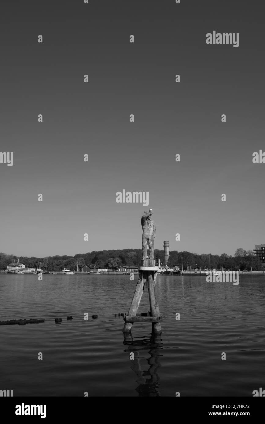 Un gabbiano su una statua di legno nel porto di Travemuende Foto Stock