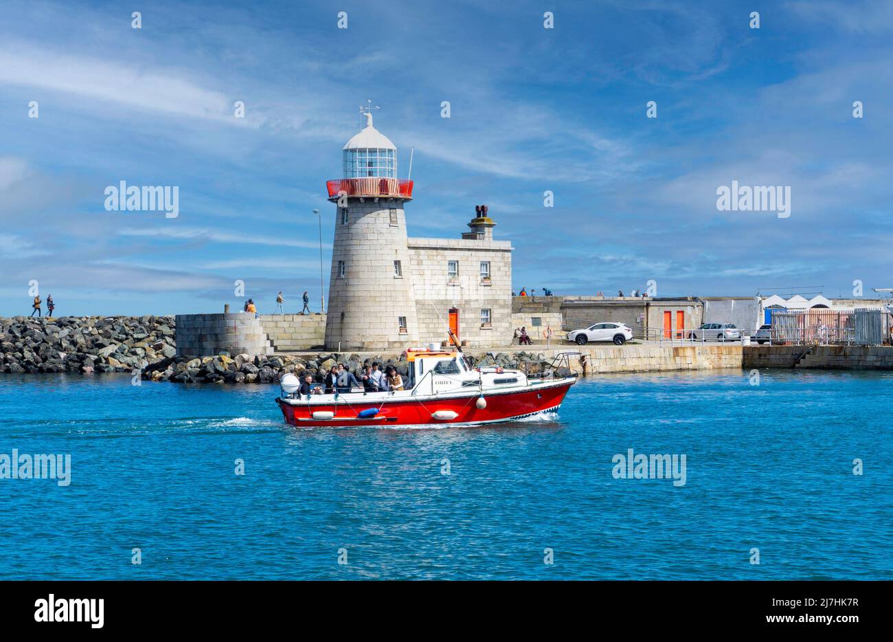 Il M.V. Oriel un piccolo traghetto disponibile per tour privati intorno Howth a Dublino, Irlanda visto qui entrare Howth Harbour e passare il faro. Foto Stock