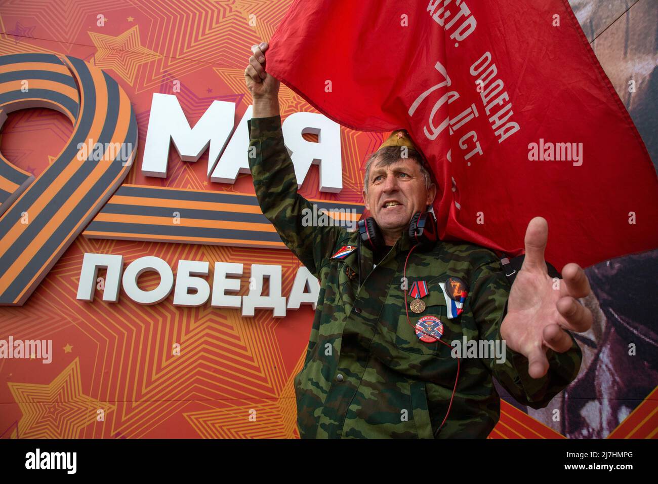 Mosca, Russia. 9th maggio 2022. Un uomo canta slogan prima dell'inizio della marcia del reggimento immortale in via Tverskaya a Mosca, Russia. L'evento celebra la sconfitta della Germania nazista da parte dell'Unione Sovietica durante la seconda guerra mondiale Il banner recita 'il 9 maggio. La Vittoria". Nikolay Vinokurov/Alamy Live News Foto Stock