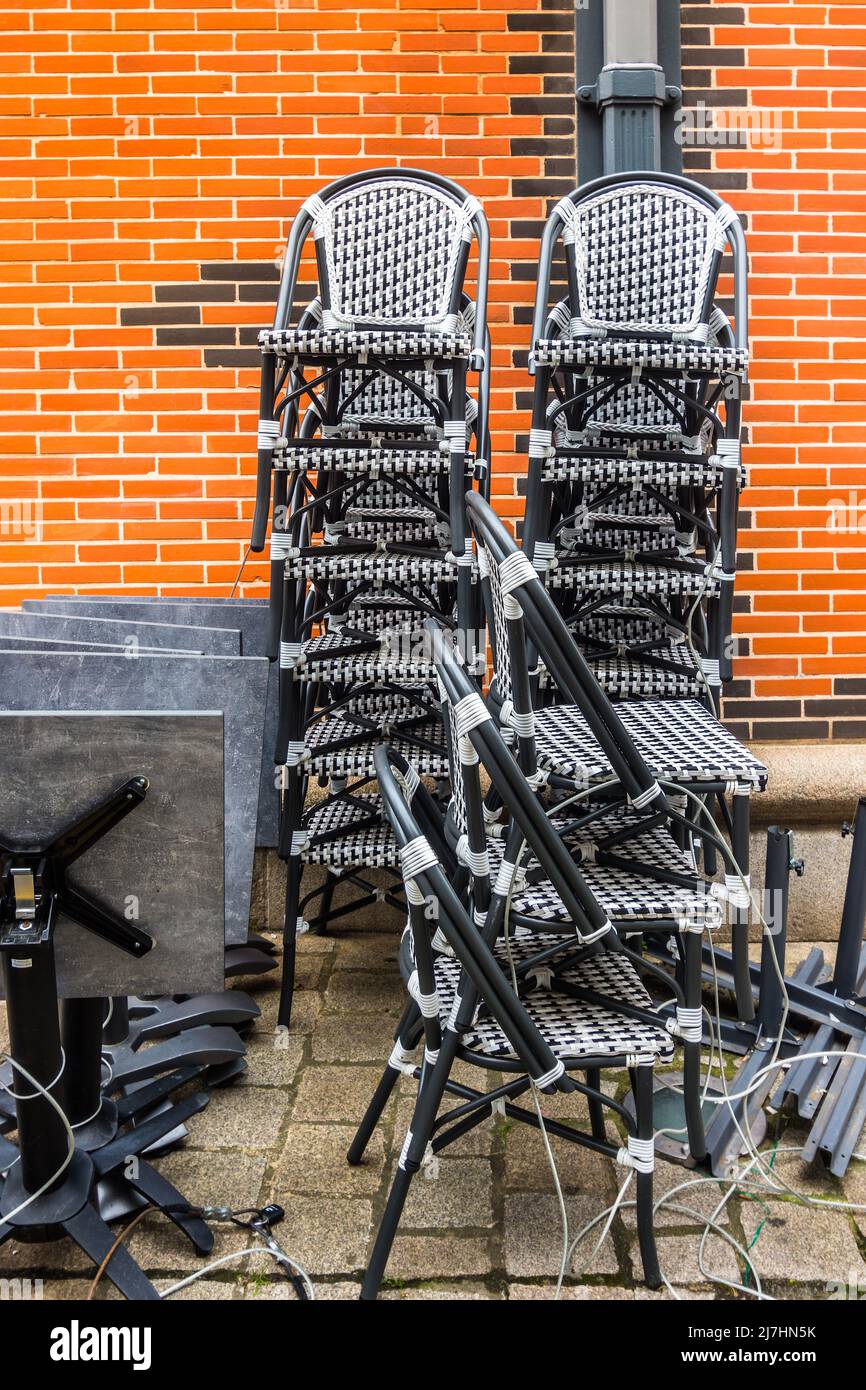 Pila di sedie da caffè chiuso con filo di sicurezza durante la notte - Limoges, Haute-Vienne (87), Francia. Foto Stock