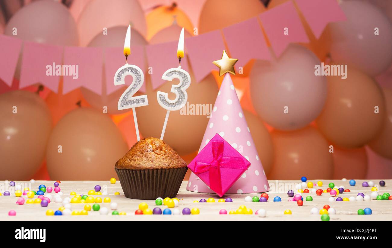 Decorazioni palloncino e una candela di compleanno felice con un numero in  una torta. Auguri di buon compleanno in colori rosa per una ragazza, spazio  copia. Muffin Foto stock - Alamy