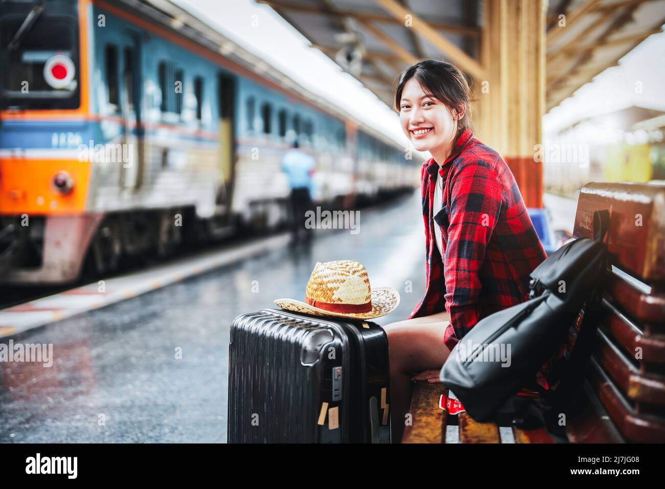 Estate, relax, vacanza, viaggio, ritratto di simpatica ragazza asiatica che mostra il sorriso e l'attesa alla stazione ferroviaria per un viaggio estivo. Foto Stock