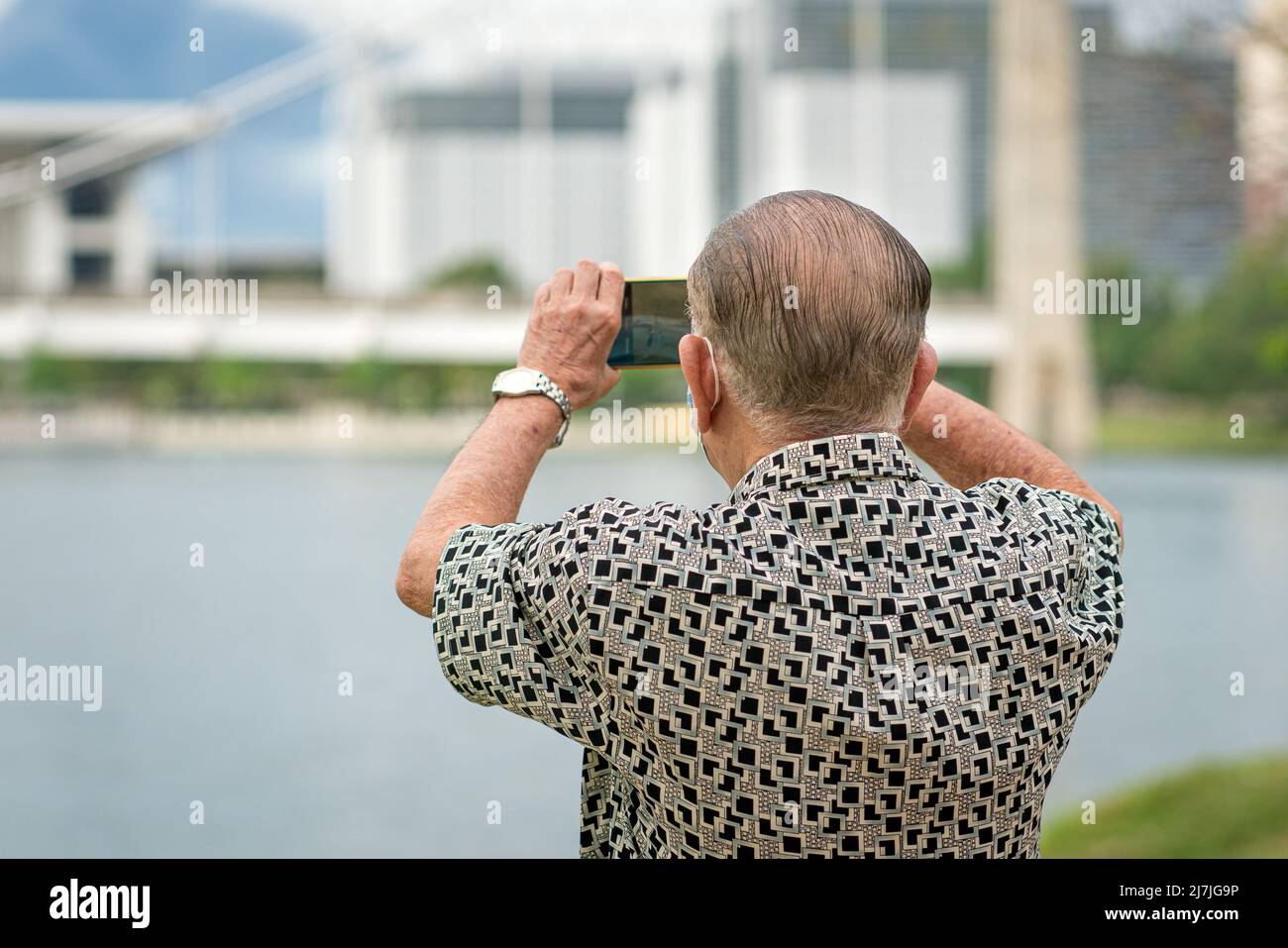 Uomo anziano che utilizza lo smartphone per scattare foto e registrare video. Viaggi e tecnologia stile di vita per anziani. Foto Stock