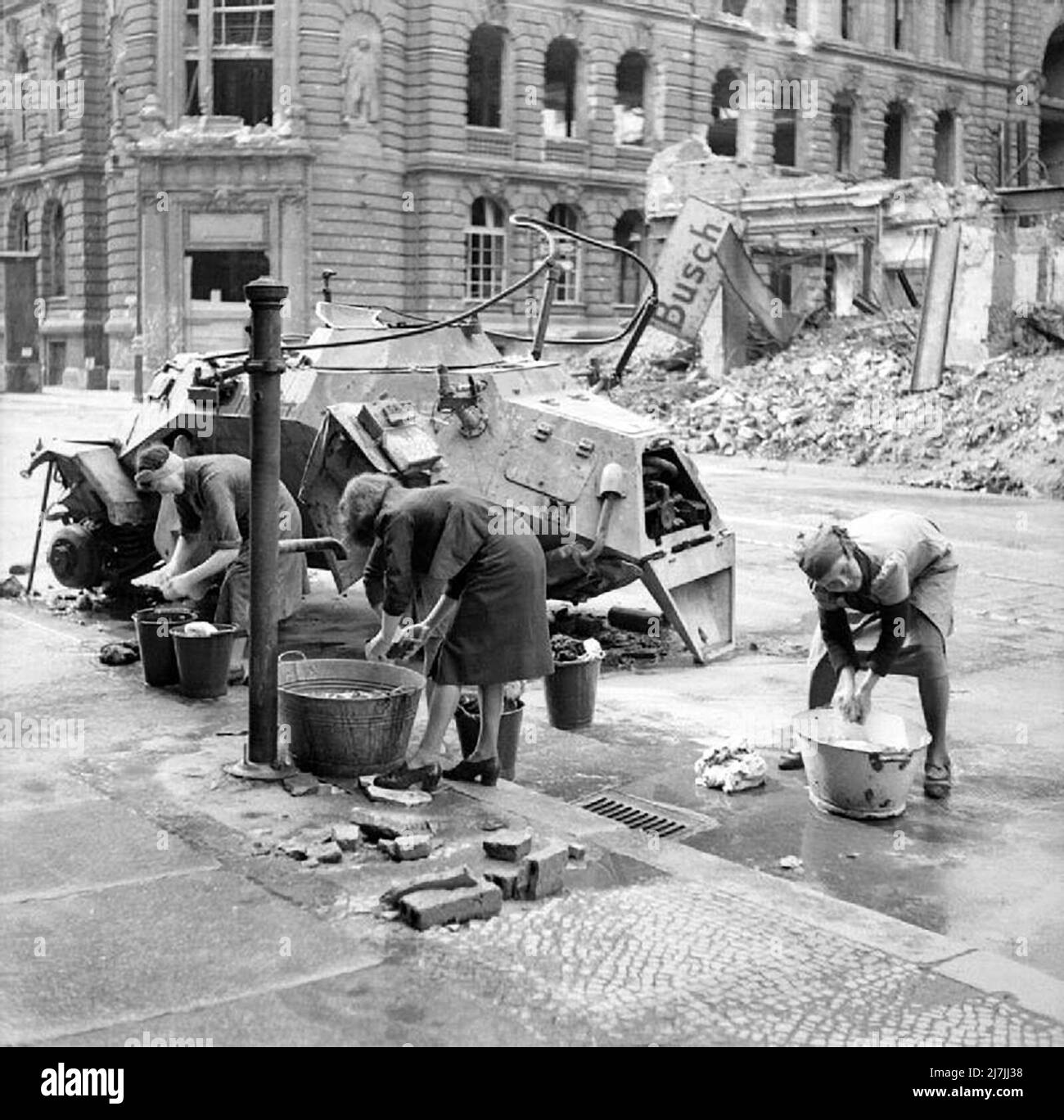 Le donne tedesche lavano i vestiti ad un idrante di acqua fredda in una via di Berlino, la seconda guerra mondiale Foto Stock