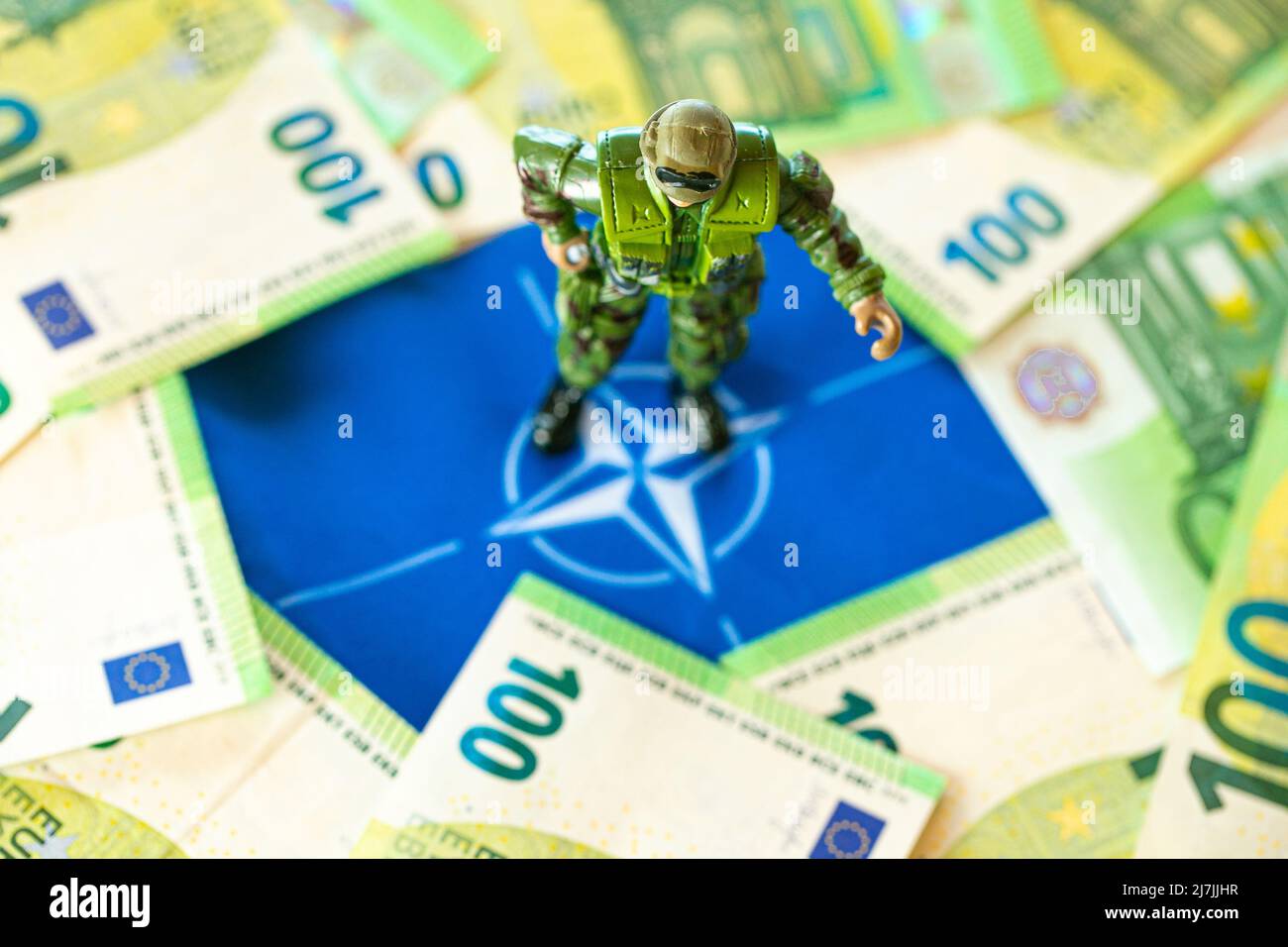 Figurine militari nella bandiera della NATO e banconote in euro.finanziamenti militari della NATO.denaro per armamenti e truppe. Spesa militare di countries.Military NATO Foto Stock