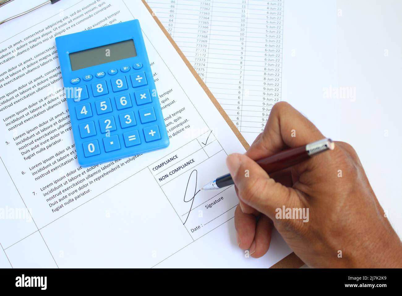 Un auditor che dà la firma al report di verifica e lo ha controllato con il risultato nella casella di controllo, dopo aver verificato i risultati. Verifica del concetto di conformità. Foto Stock