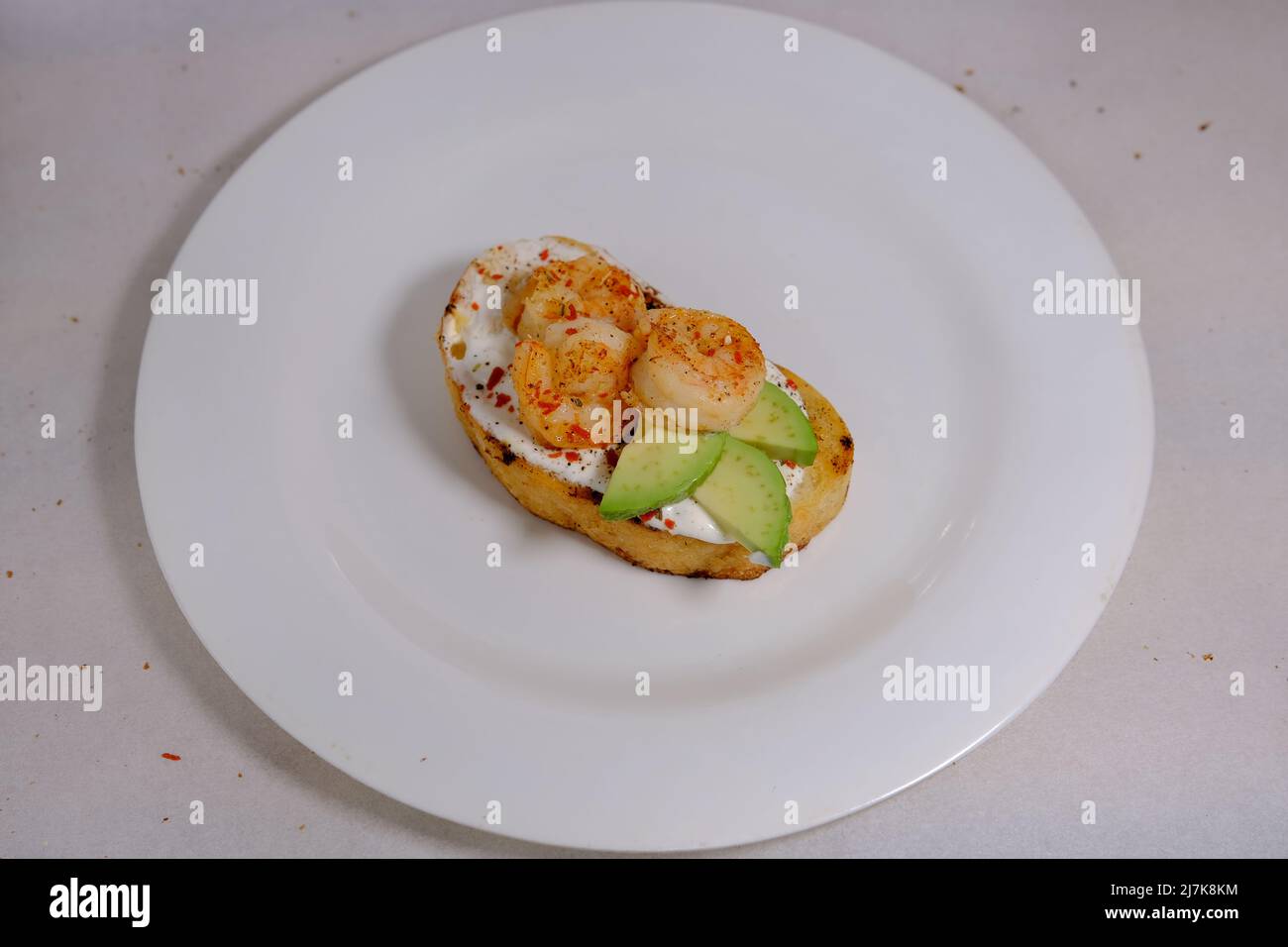 Panini all'avocado, con stagame e gamberetti su sfondo bianco Foto Stock