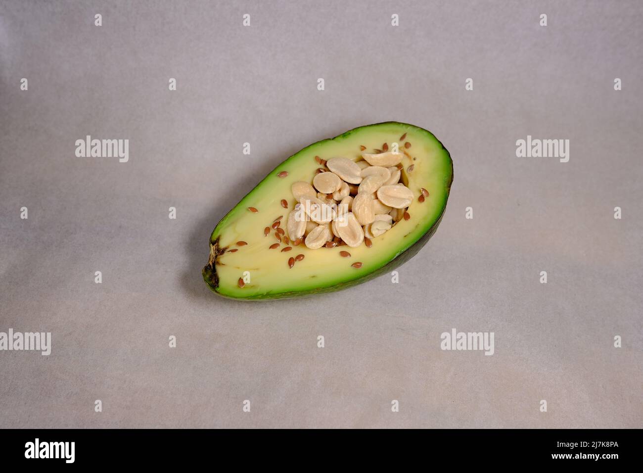 Frutti di avocado isolati su sfondo bianco con texture e arachidi all'interno e semi di colore marrone Foto Stock