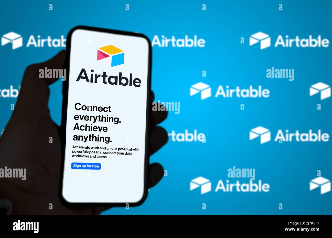 San Francisco, CA, US, maggio 2022: Mano maschile che tiene un telefono con Airtable Company pagina web sullo schermo. Sullo sfondo il logo Airtable sfocato e r Foto Stock