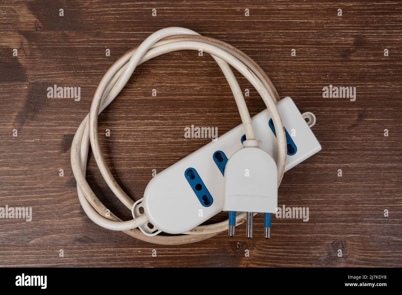 una prolunga elettrica arrotolata su una superficie di legno Foto stock -  Alamy