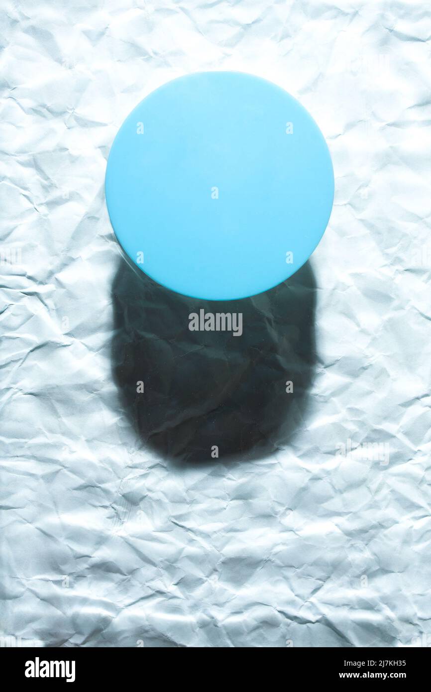 Oggetto rotondo blu su sfondo blu astratto. Piano minimalista singolo oggetto con ombra. Foto Stock