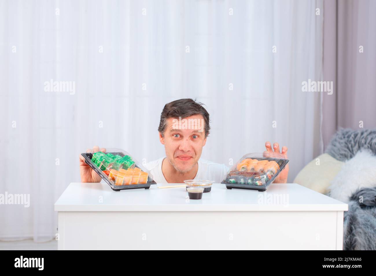 L'uomo caucasico per la prima volta prova i panini asiatici del sushi del cibo Foto Stock