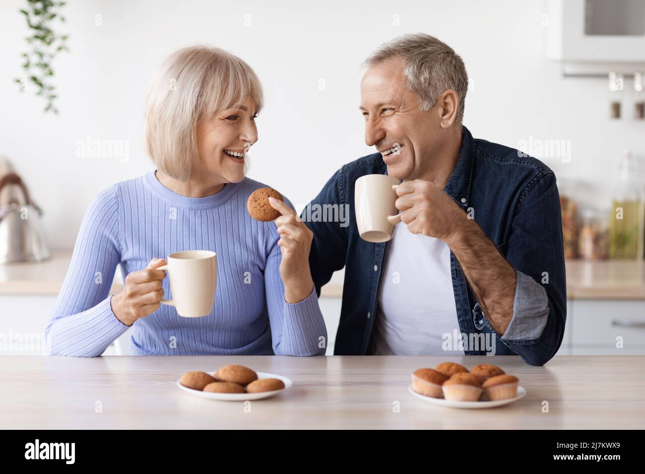 Uomo e donna anziani allegri che bevono tè a casa Foto Stock